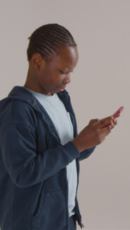 Vertical-Video-Of-Excited-Boy-On-ASD-Spectrum-Gaming-On-Mobile-Phone-On-White-Background-1